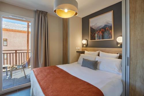 Un pat sau paturi într-o cameră la Résidence Prestige Odalys Le Mont d'Auron