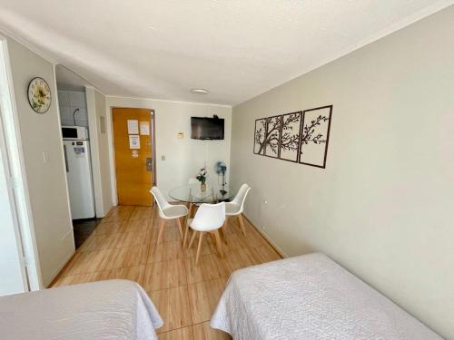 a room with two beds and a table and chairs at Acuña & Donoso Apartamentos Centro in Santiago