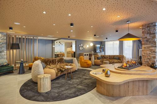 un grand salon avec des canapés et une table dans l'établissement Résidence Prestige Odalys Le Mont d'Auron, à Auron