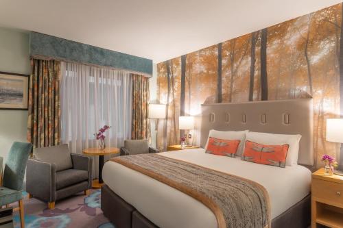 um quarto de hotel com uma cama grande e uma cadeira em Crowne Plaza Dublin Airport, an IHG Hotel em Santry