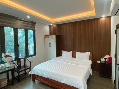 um quarto com uma cama, uma secretária e uma janela em Joy Nibi Guest House em Ninh Binh