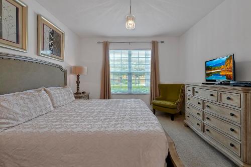 1 dormitorio con 1 cama y vestidor con TV en WATERSONG RESORT Pool & Spa GAMES ROOM 338 by Orlando Holiday Rental Homes, en Davenport