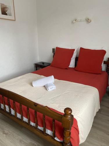 a bedroom with a bed with red and white pillows at L' Auberge Campagnarde, Lourdes in Poueyferré