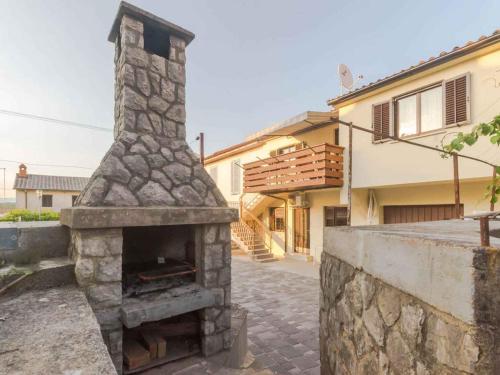 a stone fireplace in front of a house at Apartment in Njivice/Insel Krk 27855 in Njivice