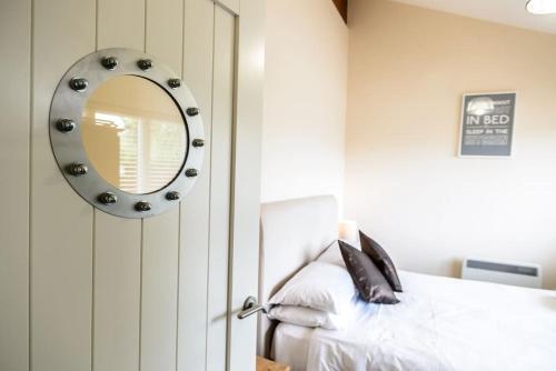 a bedroom with a mirror next to a bed at No 10 The Towans in St Merryn