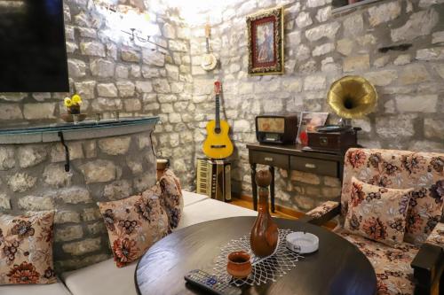 a living room with a table and a guitar at Villa Oda Tomori in Berat