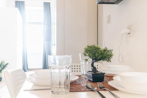 a table with white dishes and a plant on it at Neighboring 3 Apts.- Ideal for Families & Friends in Vienna