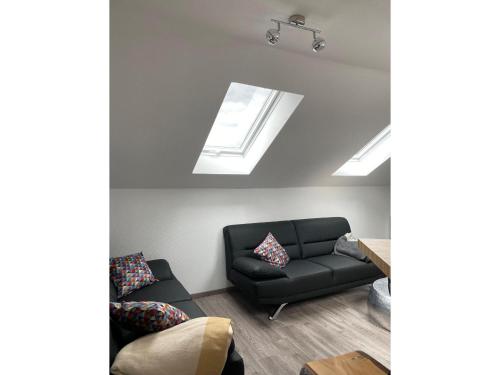 a living room with a black couch and skylights at Camping Oase Wahlhausen in Wahlhausen