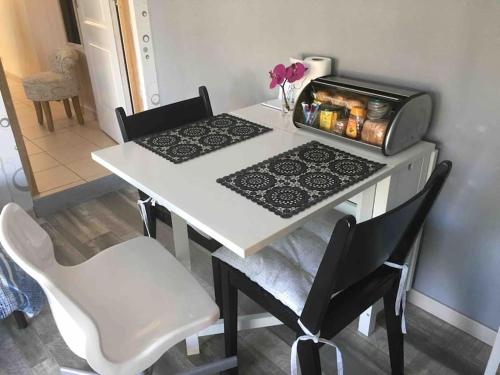 - une table à manger avec une table et des chaises blanches dans l'établissement STUDIO TERRASSE Bayeux, à Saint-Vigor-le-Grand