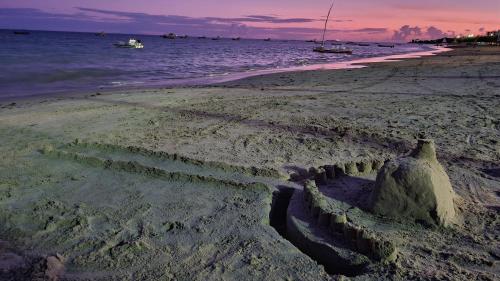 a sand castle on the beach at sunset at Apartamento Beira Mar de Pajuçara / Maceió in Maceió