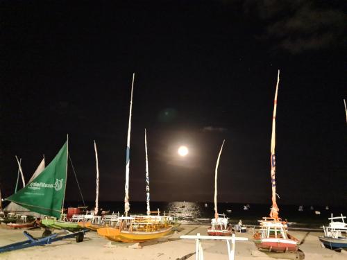 a group of boats parked on the beach at night at Apartamento Beira Mar de Pajuçara / Maceió in Maceió