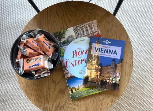 een houten tafel met twee boeken en een tijdschrift bij The blue VIEcation apartment in Wenen