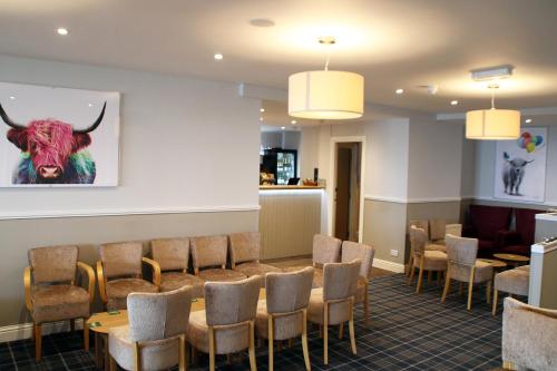 a waiting room with chairs and a bull painting on the wall at Selborne Hotel in Dunoon