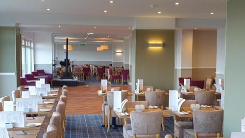 a dining room with tables and chairs and a cafeteria at Selborne Hotel in Dunoon