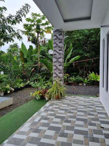 a porch with a brick pillar and plants in a garden at Ocean View Villa in Bohol in Lila
