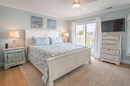 a bedroom with a bed and a dresser and a window at Second Row - Ocean View - Near Kure Beach Pier in Kure Beach