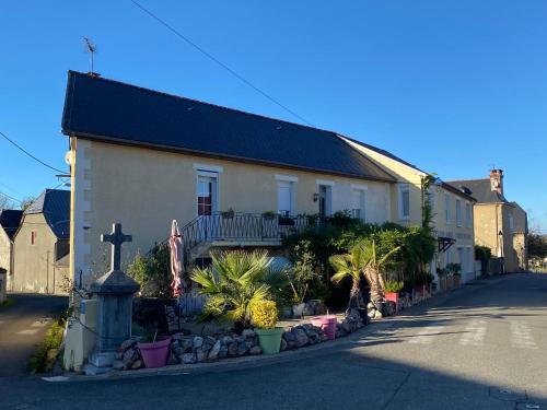 a house with a cross on the side of a street at L' Auberge Campagnarde, Lourdes in Poueyferré