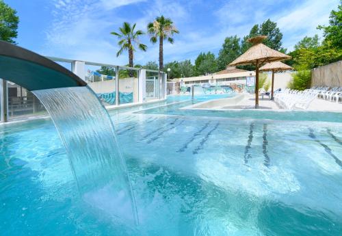 une piscine avec une fontaine au milieu dans l'établissement Camping L'EDEN, au Grau-du-Roi
