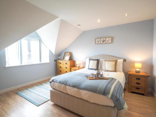 a bedroom with a king sized bed and a window at Tradewinds Gwbert in Towyn