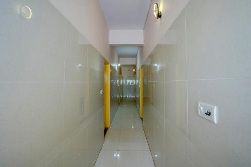 a hallway with yellow dividers in a white bathroom at Hotel O VBH Inn in Bengaluru
