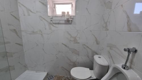 une salle de bain blanche avec toilettes et fenêtre dans l'établissement Happen!ng, à Faro
