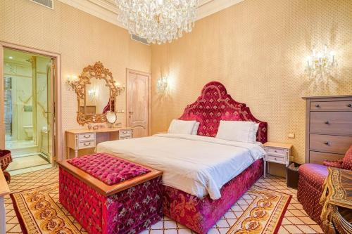 a bedroom with a large bed and a chandelier at Napoleon Suite Champs Elysees in Paris