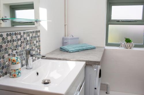 a bathroom with a white sink and a window at The Dairy Newport, Pembrokeshire in Newport Pembrokeshire