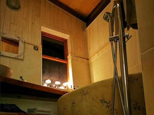 baño con bañera y ventana en Waterbessiebos cottage, en Tzaneen