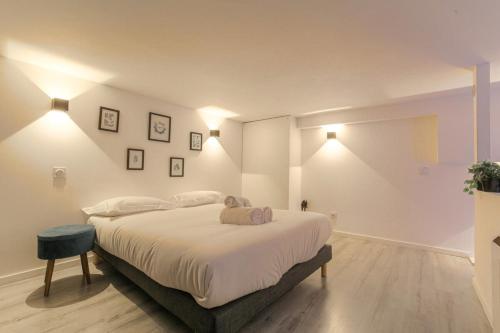 une chambre avec un grand lit avec des draps blancs dans l'établissement Duplex Design proche Part-Dieu, à Villeurbanne