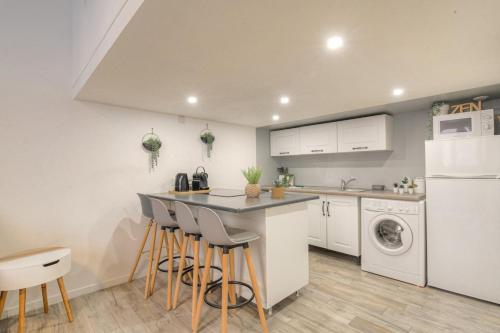 uma cozinha com um balcão e bancos numa cozinha em Duplex Design proche Part-Dieu em Villeurbanne