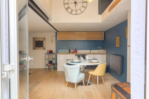 une cuisine avec une table et des chaises et une horloge au mur dans l'établissement Duplex Charmant et Calme proche Part Dieu, à Lyon