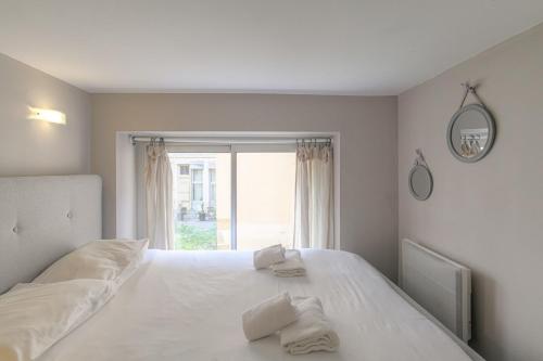 une chambre avec un lit blanc avec une fenêtre dans l'établissement Duplex Charmant et Calme proche Part Dieu, à Lyon