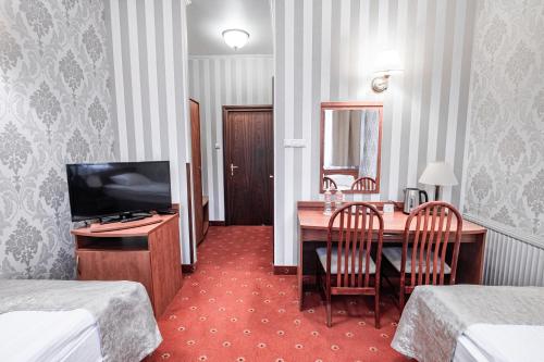 a hotel room with a desk and a television at Hotel Restauracja Browar Lwów w Lublinie in Lublin
