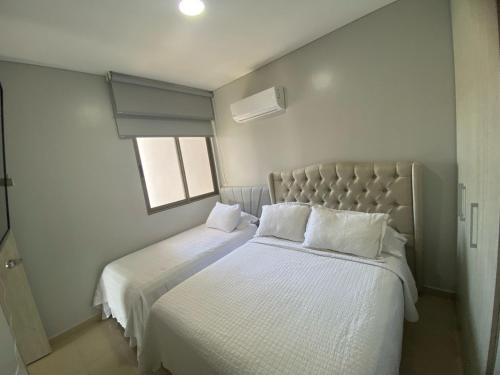 a bedroom with two beds with white sheets and a window at Apartamento Santa Marta Samaria - 3beds, 4baths, Playa Privada, Cabo Tortuga in Santa Marta