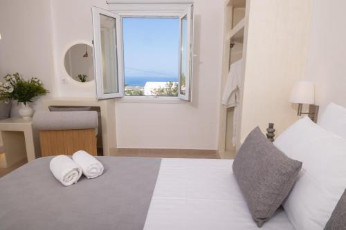 a bedroom with a bed with two towels on it at Theophrasti Suites in Foinikiá