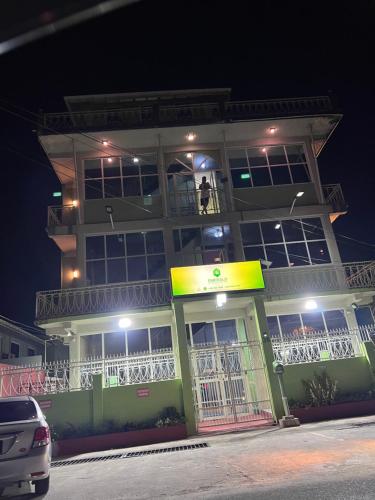 a man standing on the balcony of a building at night at Emerald Apartments INC in Georgetown