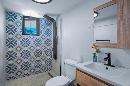 een badkamer met een wit toilet en een wastafel bij Rainforest Luxury Villa at El Yunque National Forrest in Benitez