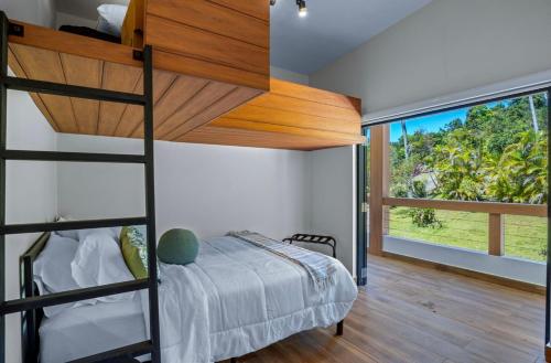 een slaapkamer met een stapelbed en een groot raam bij Rainforest Luxury Villa at El Yunque National Forrest in Benitez