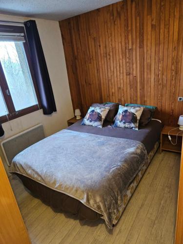 sypialnia z dużym łóżkiem i drewnianymi ścianami w obiekcie Appartement Spacieux Pra Loup T4 11 pers. 105m² w mieście Uvernet
