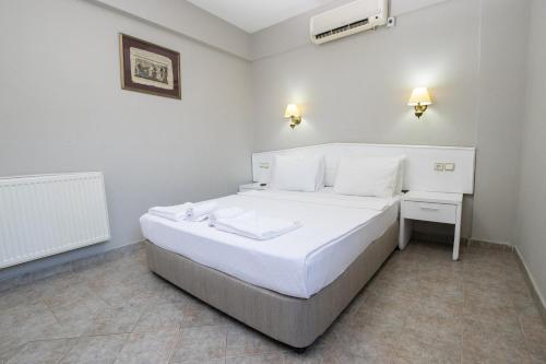 een slaapkamer met een groot wit bed in een kamer bij Sunpoint Hotel Bodrum in Bodrum City
