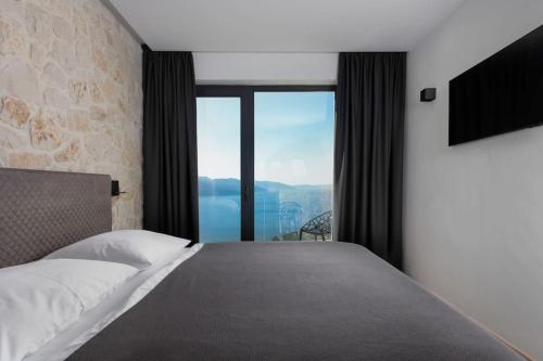 1 dormitorio con cama y ventana grande en Luksuzna moderna vila sa panoramskim pogledom, en Zagorje