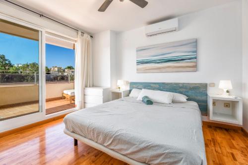 um quarto com uma cama e uma grande janela em Benalmádena Marina Golf Appartement - Casa Valk em Benalmádena