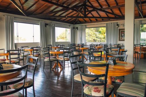 a room with tables and chairs and windows at Escarpas resort in Capitólio