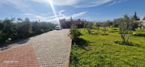 un camino que conduce a una casa en un campo en DAR MORAD villa entière avec piscine privée ds une ferme de 4Ha, en Marrakech