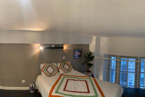 een slaapkamer met een bed en een groot raam bij Loft Atypique centre Montpellier in Montpellier