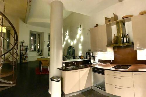 een keuken met witte kasten en een fornuis met oven bij Loft Atypique centre Montpellier in Montpellier