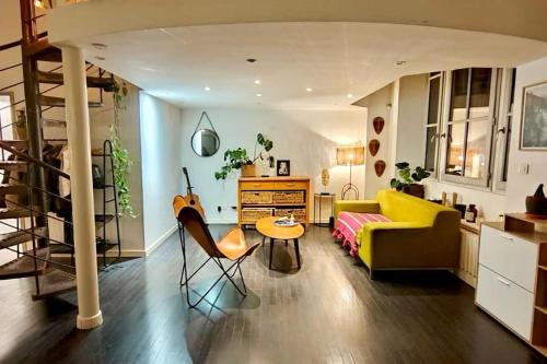 een woonkamer met een gele bank en een tafel bij Loft Atypique centre Montpellier in Montpellier