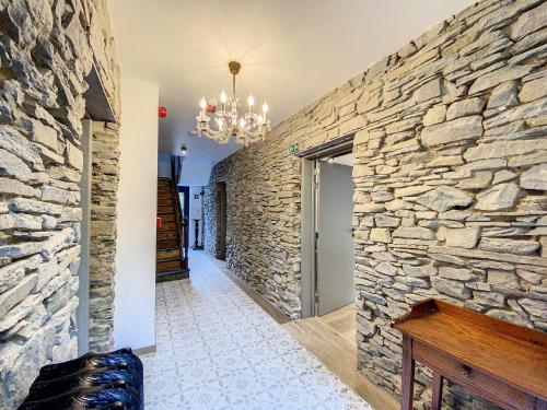 a hallway with a stone wall and a chandelier at Gîte à Esneux - A La Belle Epoque d'Esneux in Esneux