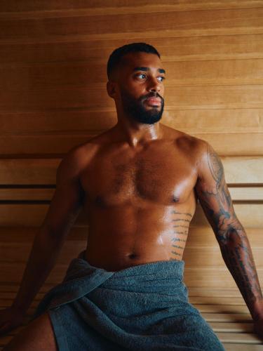 a shirtless black man sitting in a towel at Clarion Hotel Stockholm in Stockholm