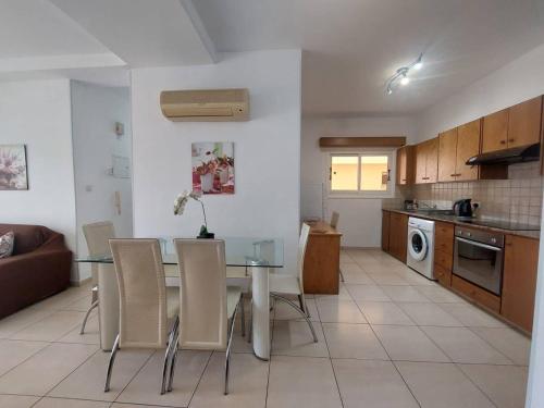 a kitchen and dining room with a table and chairs at Sunny 2 Bedroom Larnaca Center in Larnaka